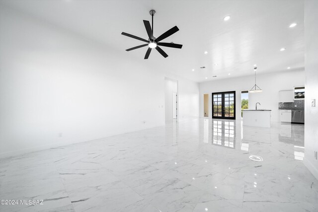 unfurnished living room with ceiling fan