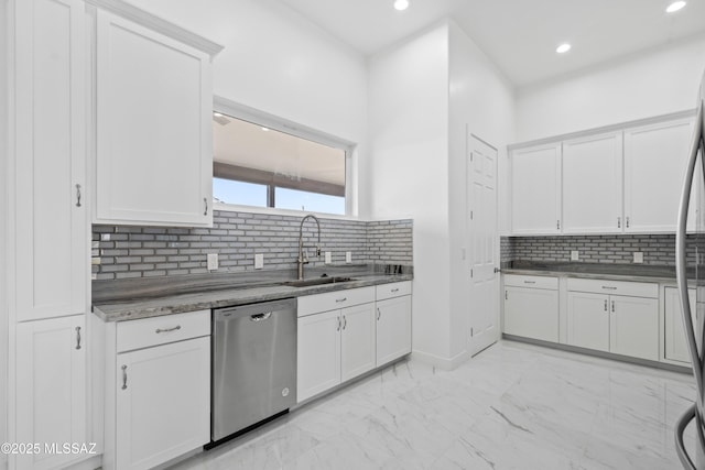 kitchen with tasteful backsplash, sink, white cabinets, and dishwasher