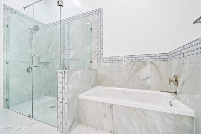 bathroom featuring shower with separate bathtub