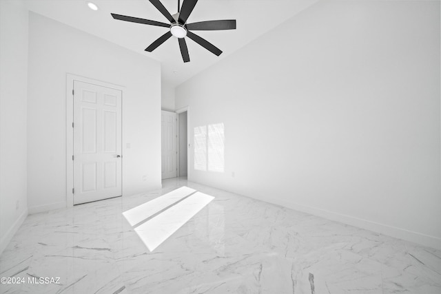 unfurnished bedroom with ceiling fan and a towering ceiling