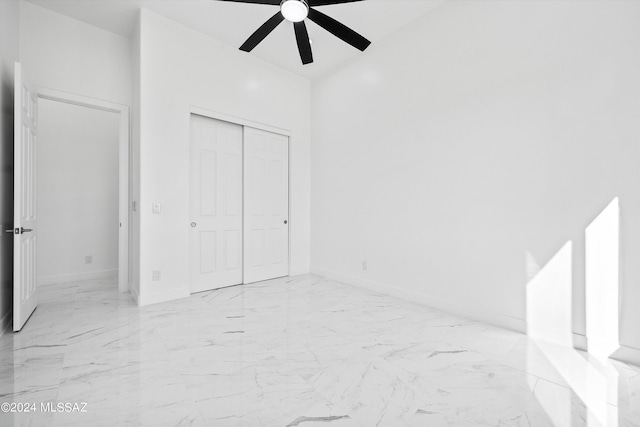 unfurnished bedroom with ceiling fan and a closet