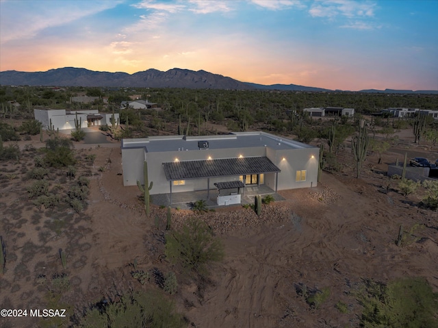 aerial view at dusk featuring a mountain view