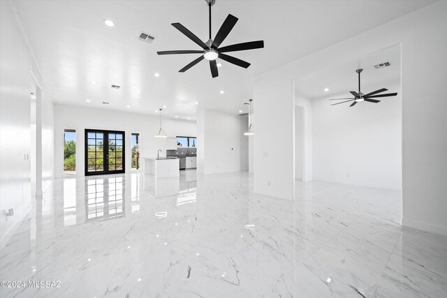 unfurnished living room with sink and ceiling fan