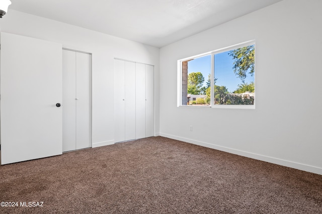 unfurnished bedroom featuring carpet floors and multiple closets