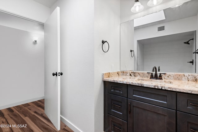 bathroom featuring a shower, vanity, and hardwood / wood-style floors