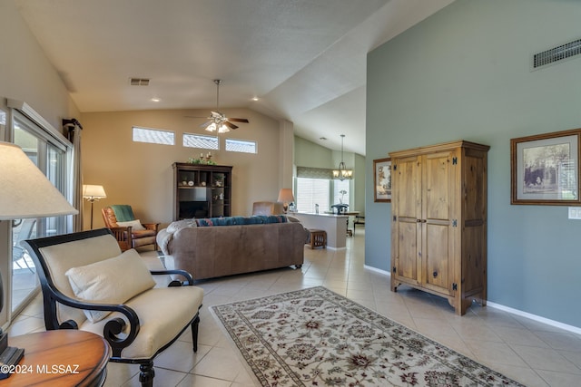 tiled living room with ceiling fan with notable chandelier and high vaulted ceiling