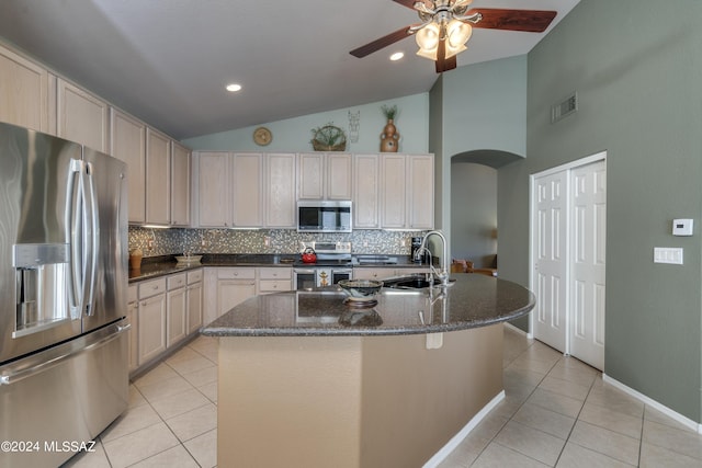 kitchen with sink, backsplash, a kitchen island with sink, light tile patterned floors, and appliances with stainless steel finishes