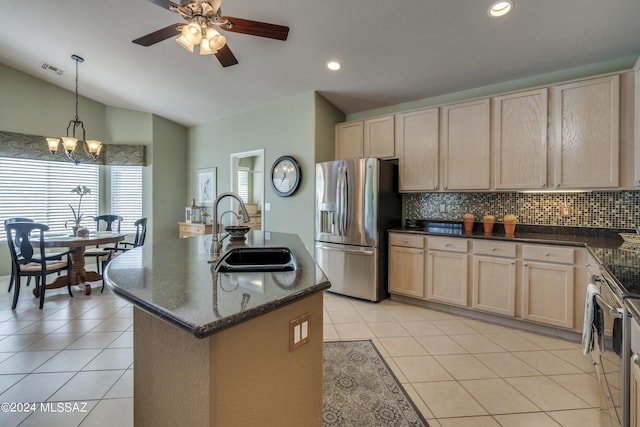 kitchen featuring decorative backsplash, appliances with stainless steel finishes, vaulted ceiling, sink, and an island with sink