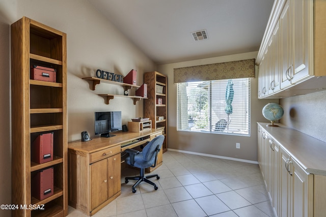 office featuring light tile patterned flooring, built in desk, and vaulted ceiling