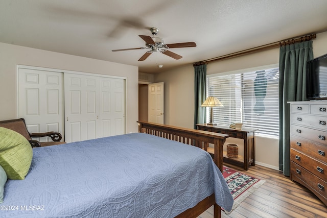 bedroom with ceiling fan, a closet, and hardwood / wood-style flooring