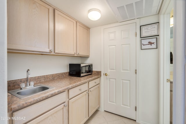 kitchen featuring light brown cabinets, light tile patterned floors, and sink