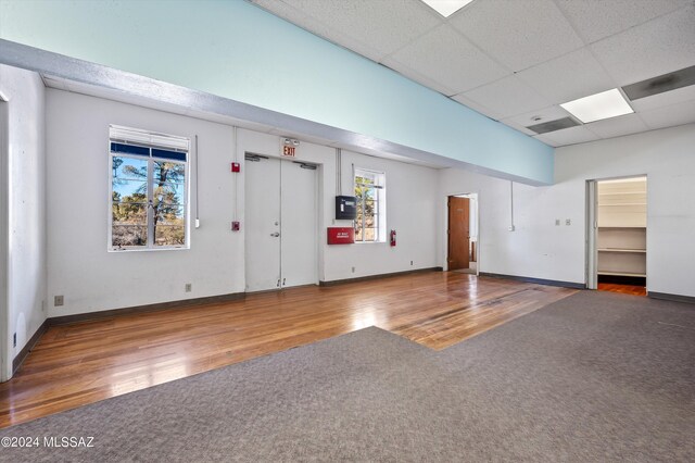 interior space featuring a paneled ceiling and dark wood-type flooring