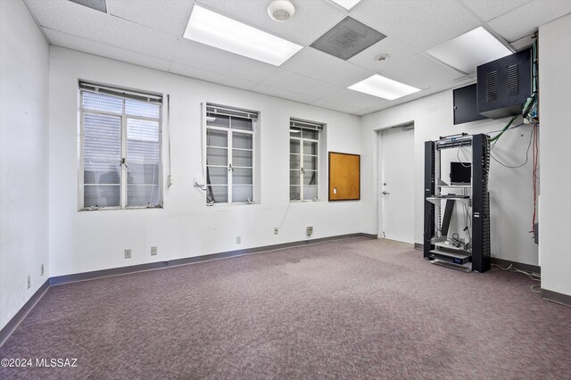 carpeted empty room with a drop ceiling