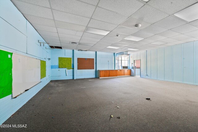 carpeted spare room with a paneled ceiling