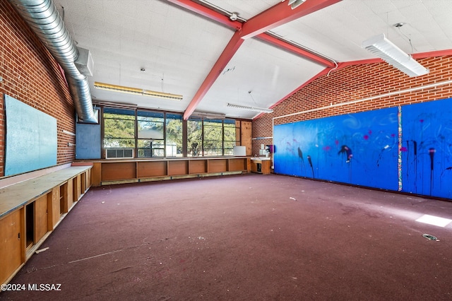 interior space with carpet flooring, lofted ceiling with beams, and brick wall