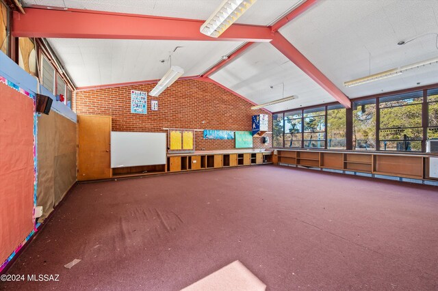 interior space with vaulted ceiling and dark colored carpet