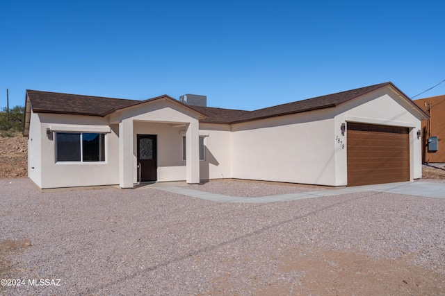 ranch-style house featuring central air condition unit and a garage