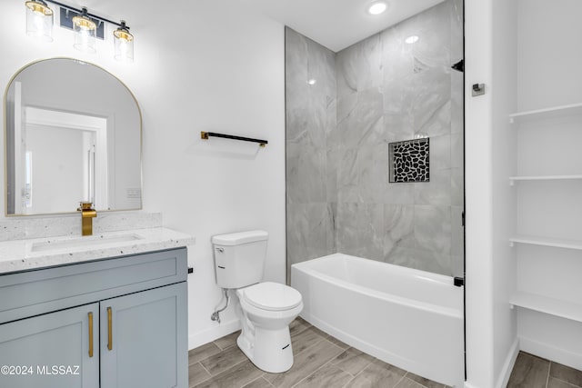 full bathroom with tiled shower / bath, toilet, and vanity