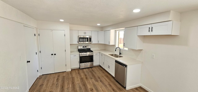 kitchen featuring tasteful backsplash, sink, white cabinetry, stainless steel appliances, and dark hardwood / wood-style flooring