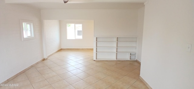 tiled empty room featuring ceiling fan