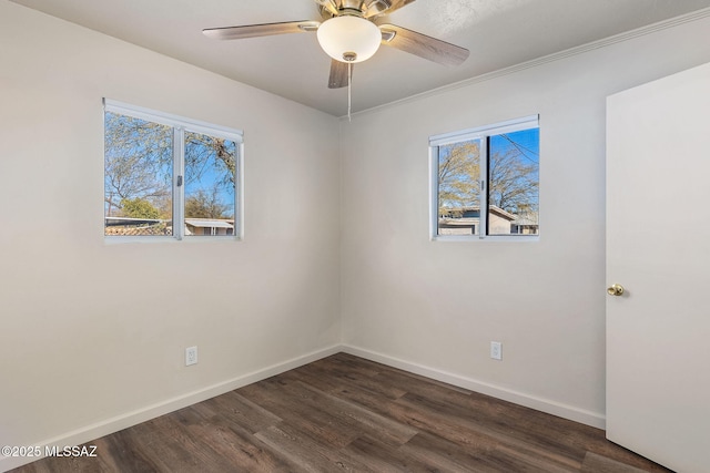 empty room with ceiling fan, ornamental molding, and dark wood-type flooring