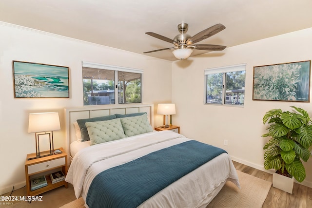 bedroom with ceiling fan, wood-type flooring, and ornamental molding