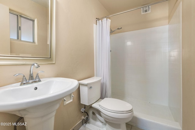 bathroom with a shower with curtain, toilet, and sink