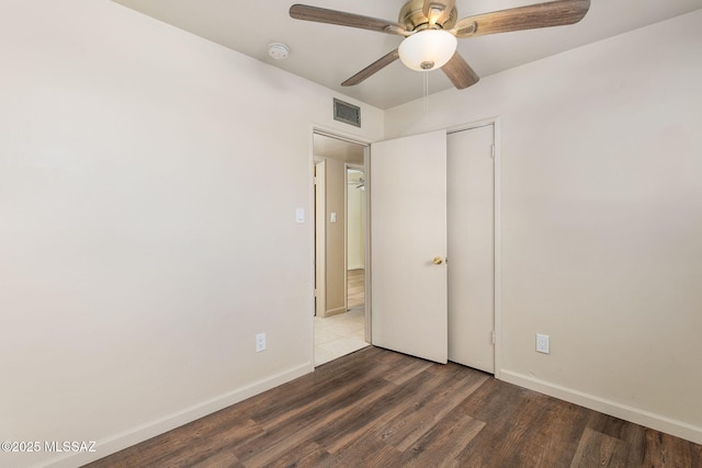 unfurnished bedroom with ceiling fan, dark hardwood / wood-style floors, and a closet