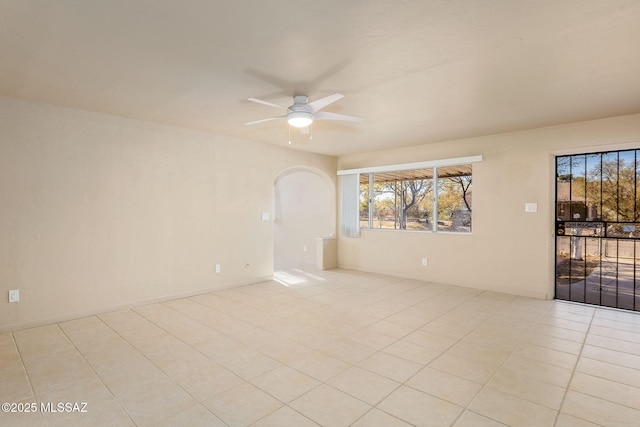 tiled spare room featuring ceiling fan