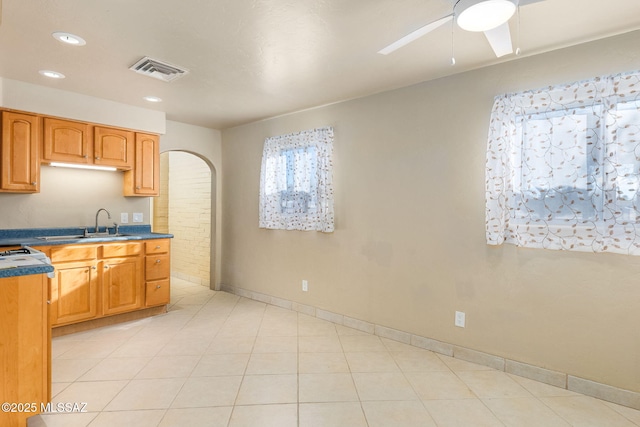 kitchen featuring ceiling fan, sink, and light tile patterned floors