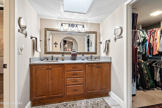 bathroom with a skylight, vanity, and tile patterned floors