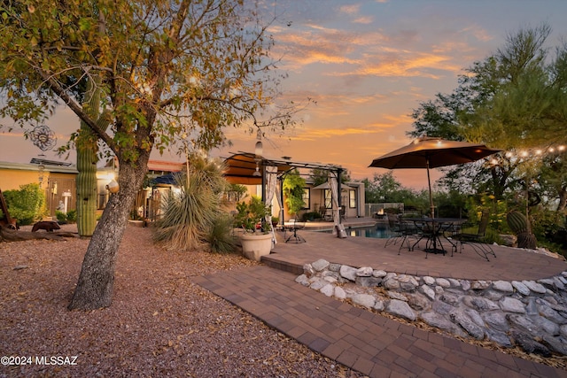 yard at dusk with a patio and a pergola