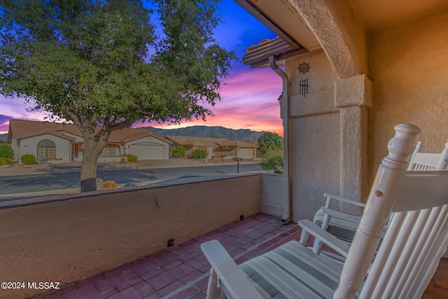 balcony at dusk featuring a mountain view