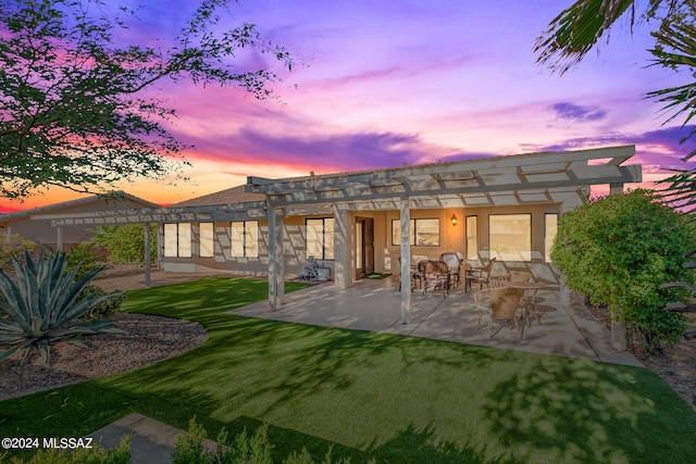 back house at dusk with a yard and a patio area