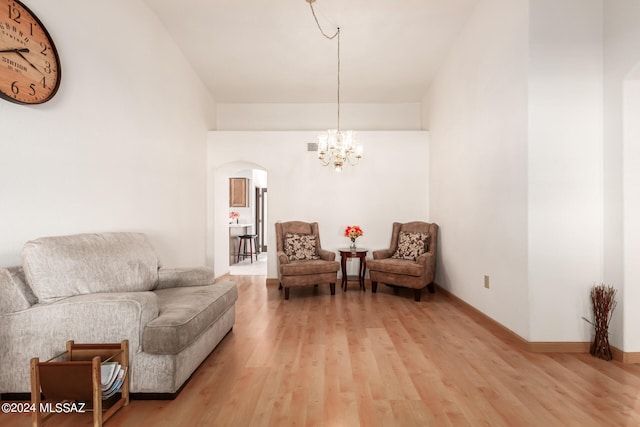 sitting room featuring an inviting chandelier and hardwood / wood-style floors