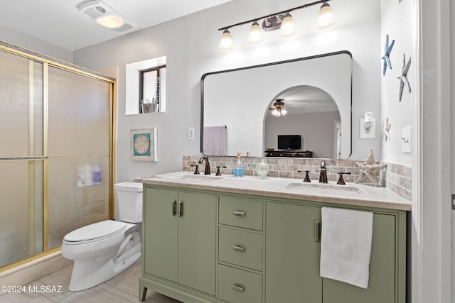 bathroom with ceiling fan, walk in shower, vanity, and toilet