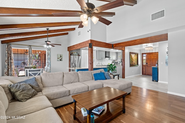 living room featuring ceiling fan, lofted ceiling with beams, and hardwood / wood-style floors