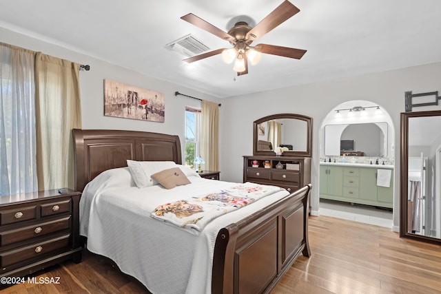 bedroom with ensuite bath, ceiling fan, hardwood / wood-style floors, and sink