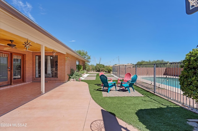 view of yard featuring fence, a patio area, a fenced in pool, and ceiling fan