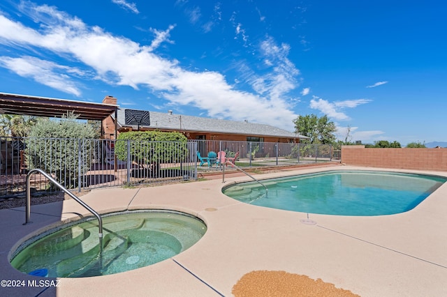 view of swimming pool with a fenced in pool, a patio, an in ground hot tub, and fence