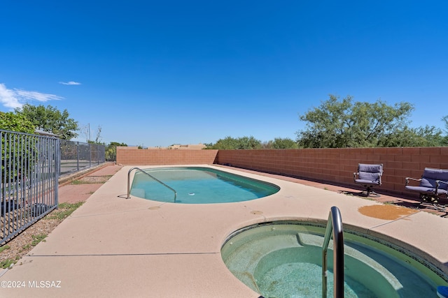 view of pool featuring a fenced in pool, a patio area, a fenced backyard, and an in ground hot tub