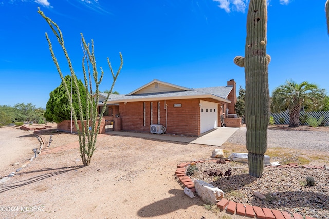 ranch-style house with a garage, fence, brick siding, and concrete driveway