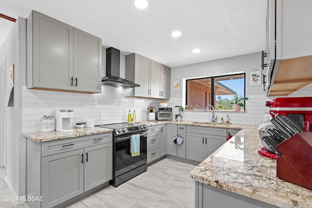 kitchen with gray cabinets, electric range, a sink, and wall chimney range hood