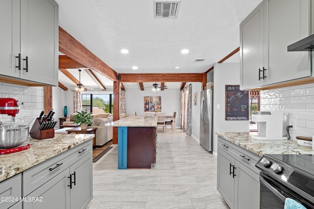 kitchen featuring open floor plan, freestanding refrigerator, decorative backsplash, ceiling fan, and range with electric stovetop