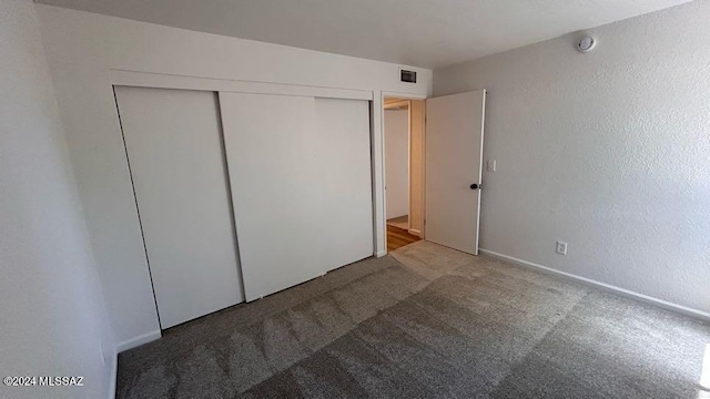 unfurnished bedroom with carpet floors and a closet