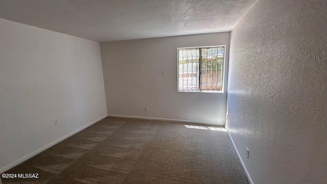 carpeted spare room with a textured ceiling