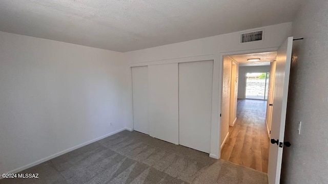 unfurnished bedroom with hardwood / wood-style floors and a closet