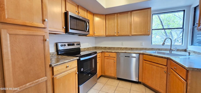 kitchen featuring stainless steel appliances, light tile patterned floors, and sink