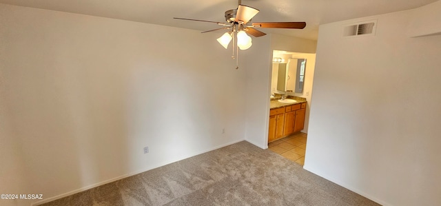 empty room featuring light carpet, ceiling fan, and sink