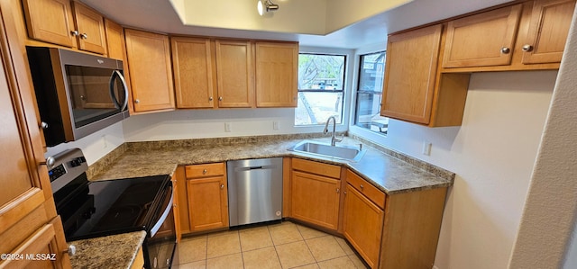 kitchen featuring light tile patterned floors, stainless steel appliances, and sink